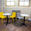 "Tuff-Top-White-600-Round-Table-tops-on-a-Phoenix-Base-with-Strata-Yellow-and-Grey-Side-Chairs.jpg"